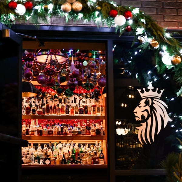 The Noble Lion bar, adorned with festive Christmas decorations and a wide selection of liquor bottles.