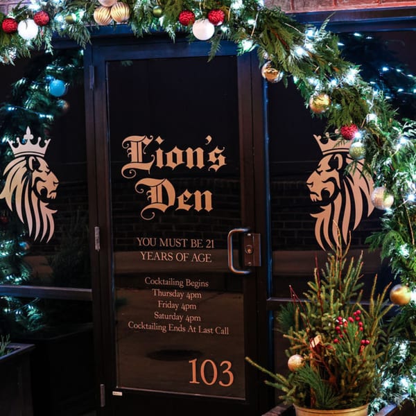The Noble Lion's "Lion's Den" entrance, adorned with festive garlands and holiday decorations.
