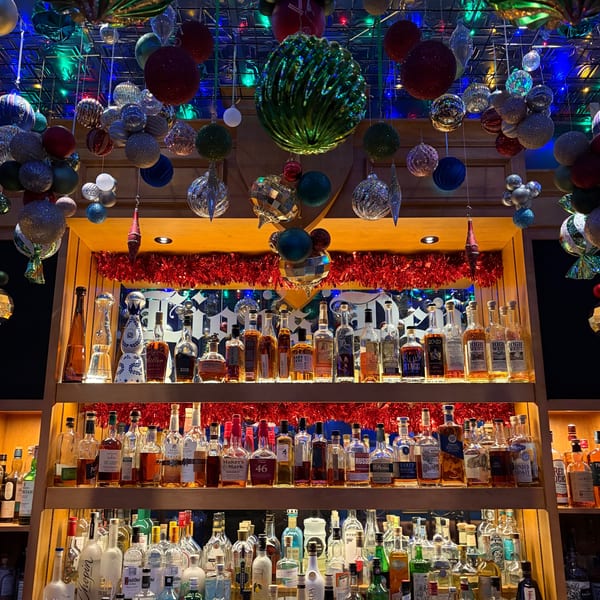 A festive bar at The Noble Lion, adorned with Christmas ornaments and shelves of liquor bottles.